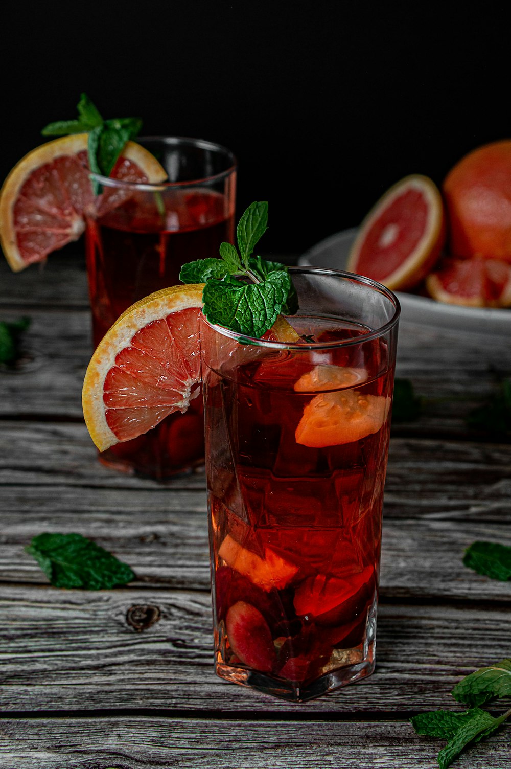 clear drinking glass with red liquid and sliced orange