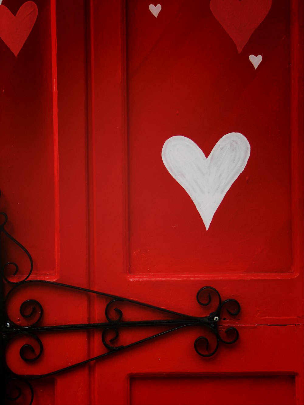 porta de madeira vermelha com coração em forma de coração branco em forma de coração