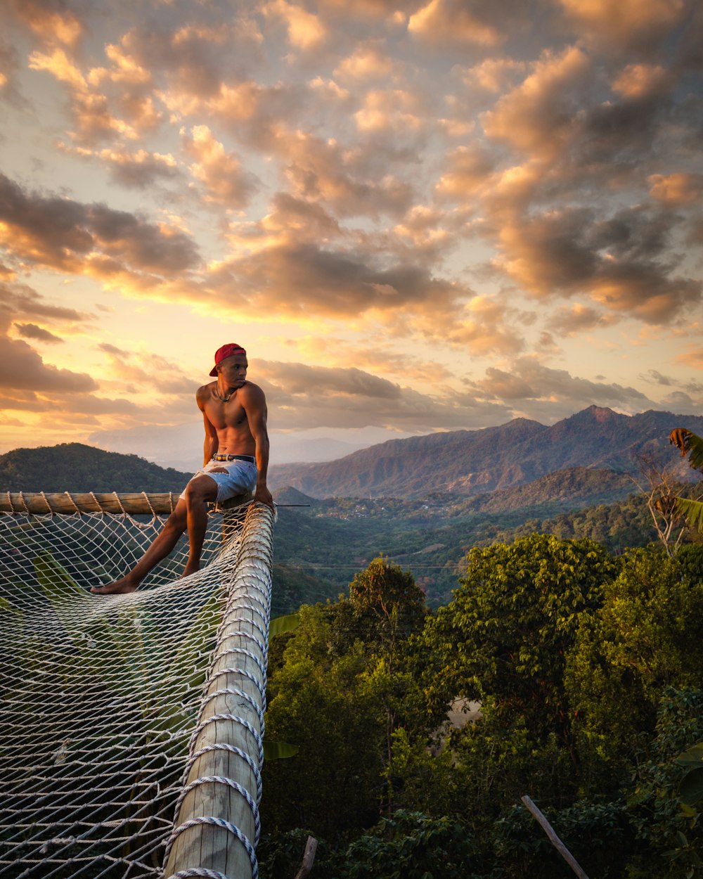 woman in blue bikini sitting on white wooden fence during daytime