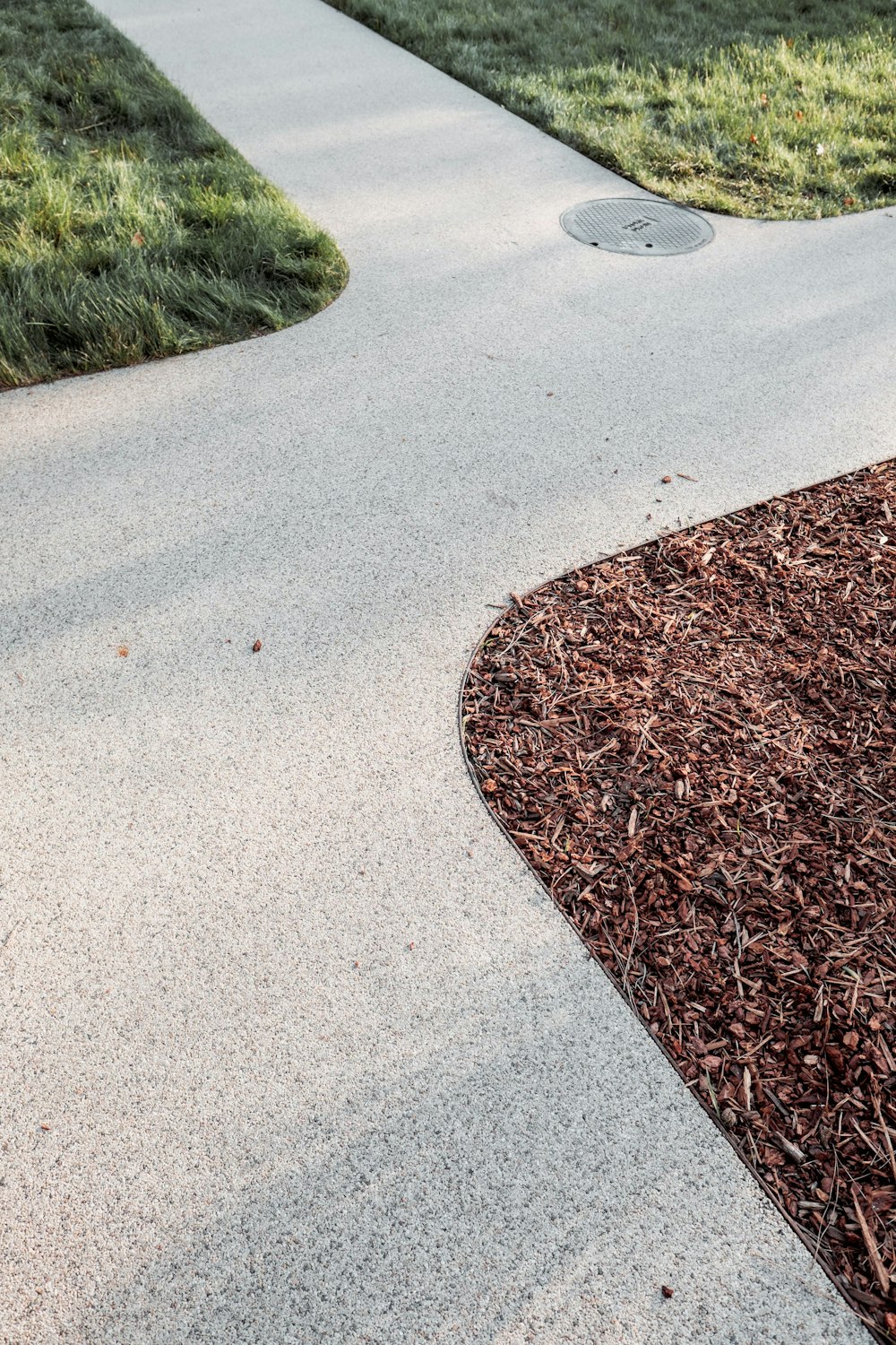 Graue Betonstraße in der Nähe von Green Gras Field tagsüber