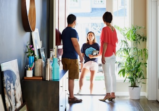 2 women standing beside man in blue t-shirt