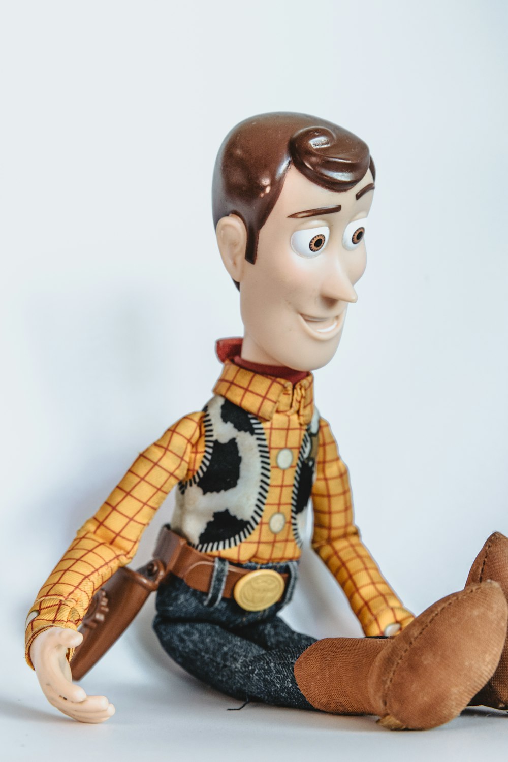 brown haired boy in yellow and black plaid dress shirt and blue denim jeans figurine