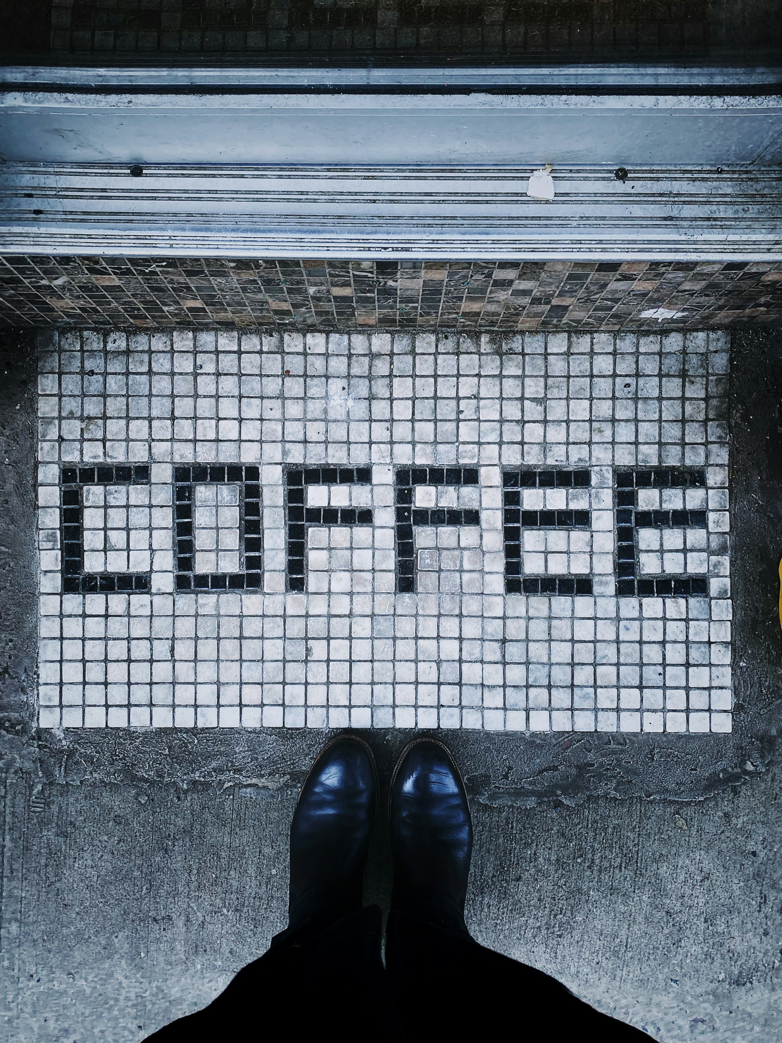personne en chaussures en cuir noir debout sur le sol en béton gris