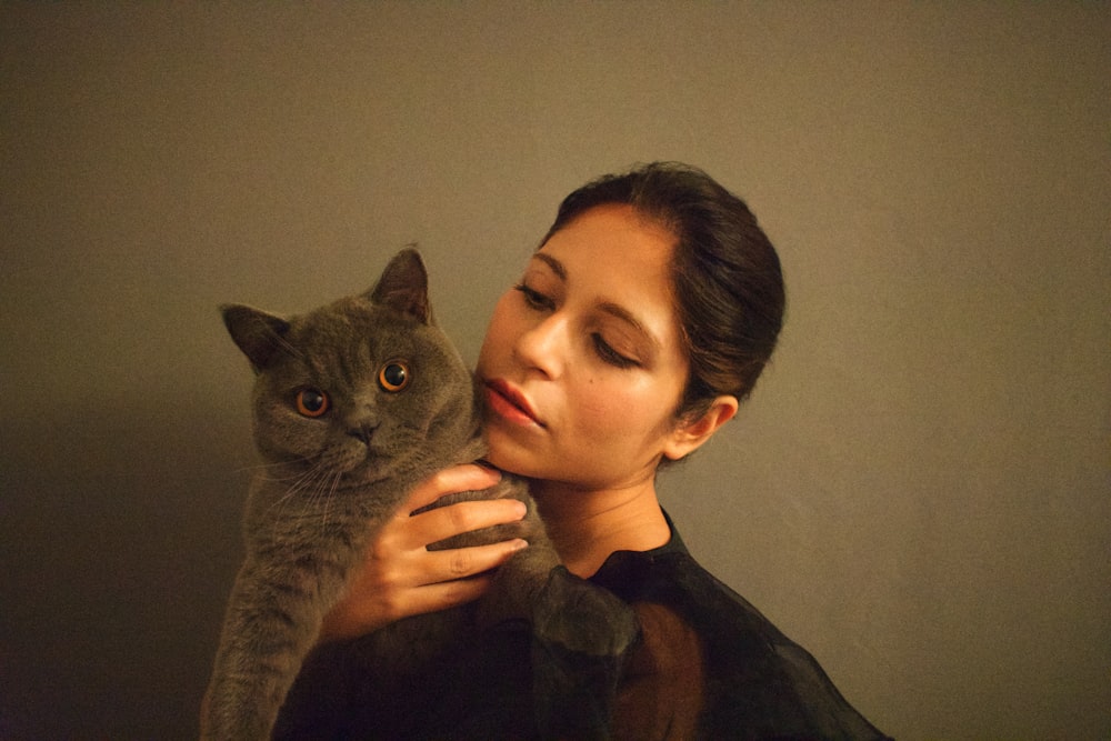 woman in black shirt holding gray cat