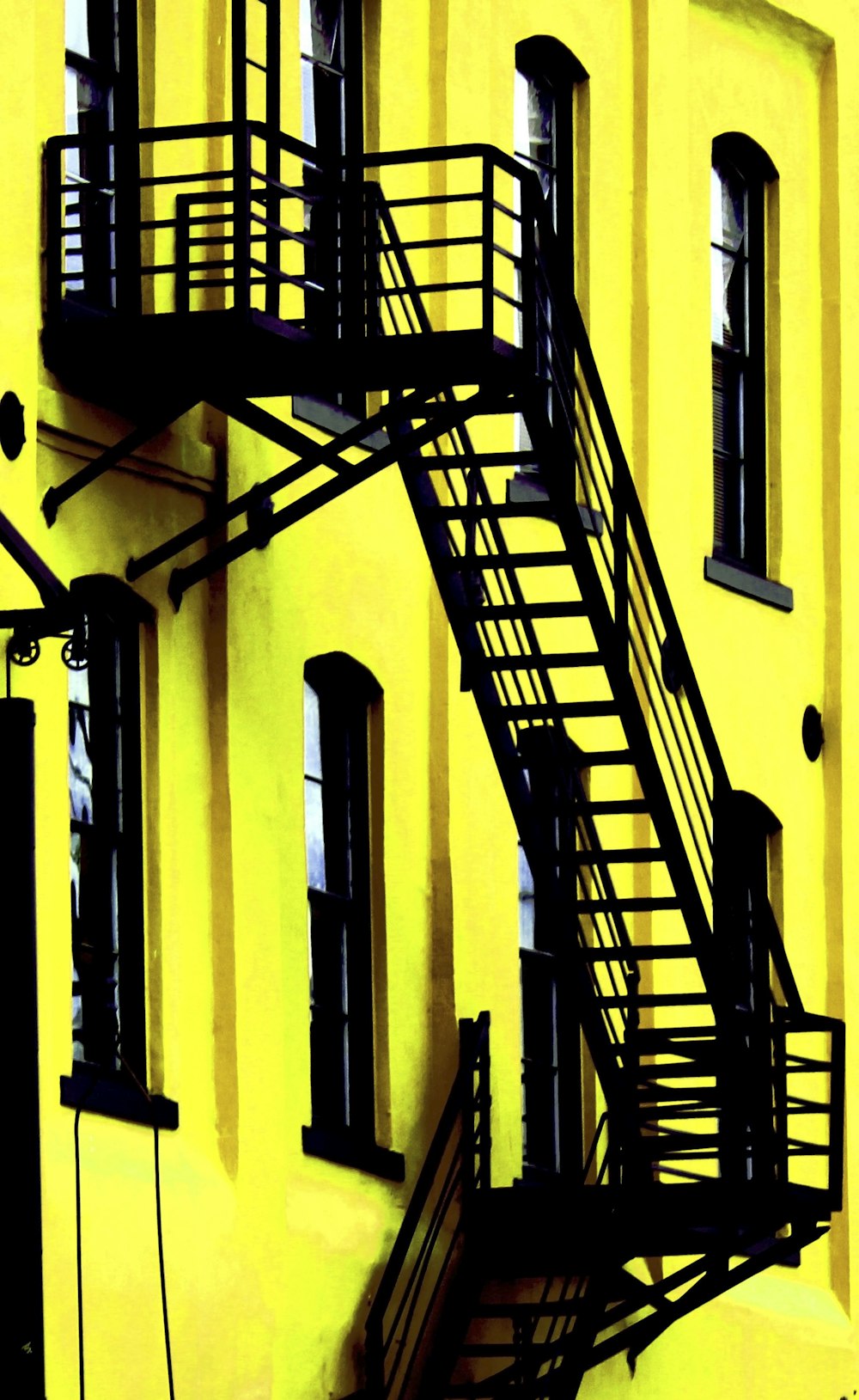 black metal ladder on yellow painted wall