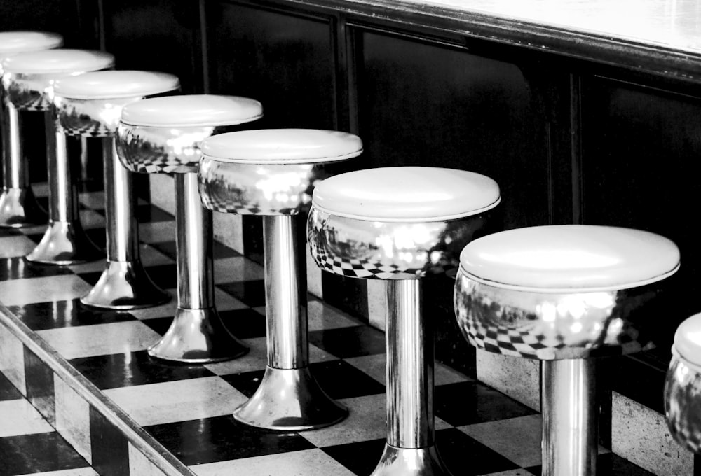 stainless steel bar stools on black and white checkered floor