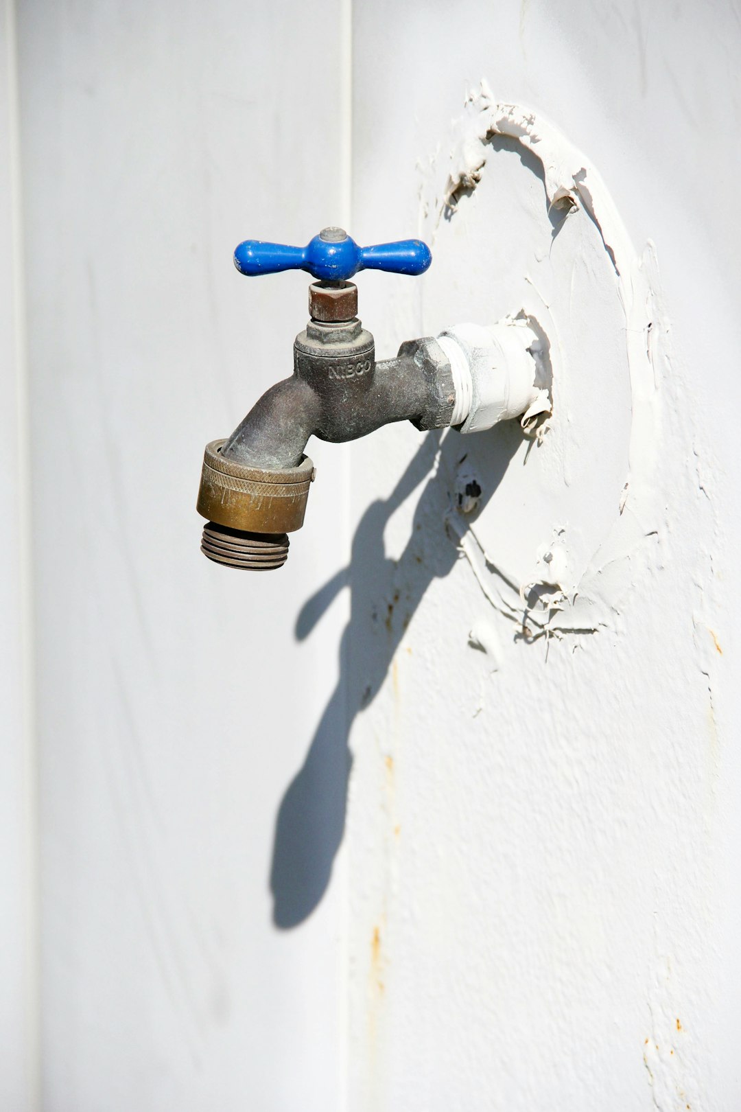  brown and black pipe on white wall tap