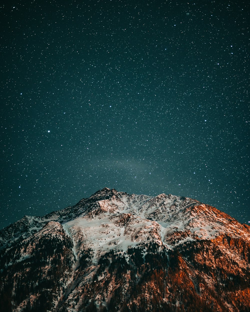 snow covered mountain under starry night