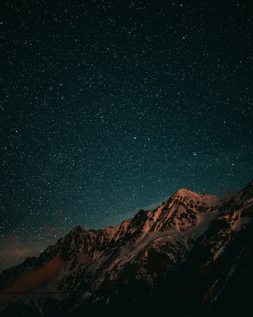 夜の青空の下に茶色と黒の山