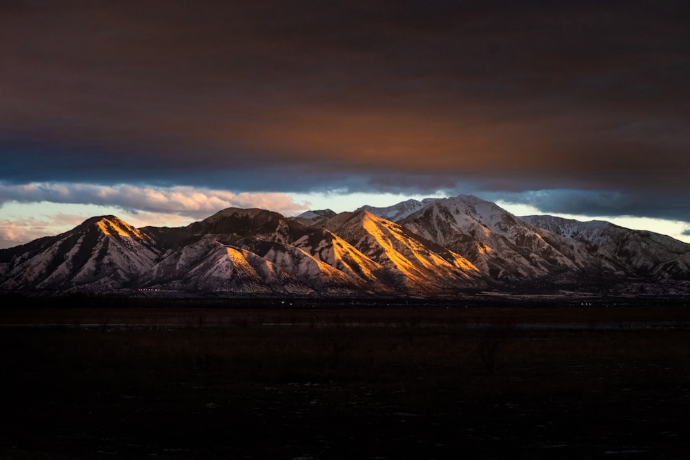 brown and white mountains under gray sky