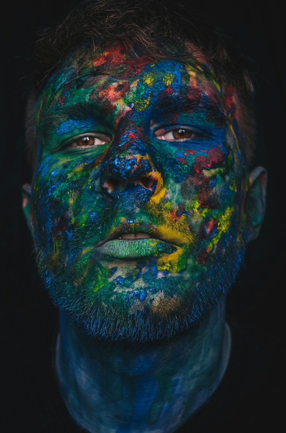 man with blue green and yellow face paint