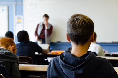 boy in black hoodie sitting on chair school google meet background