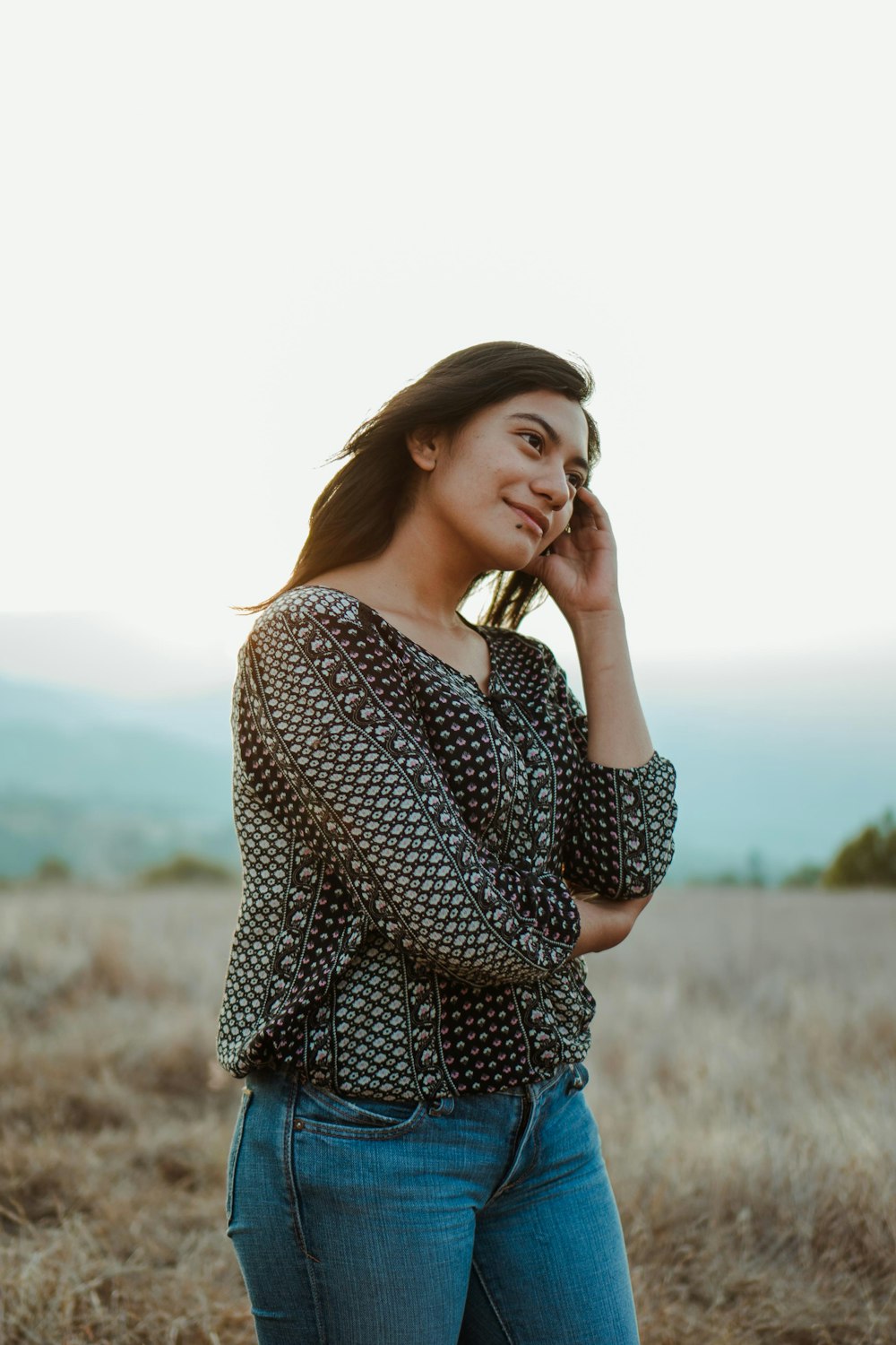 woman in black and white long sleeve shirt standing on brown grass field during daytime