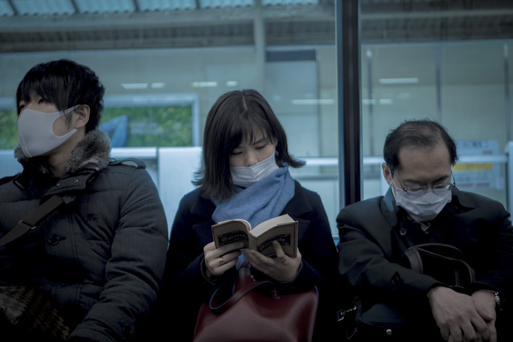 man in black jacket holding white smartphone beside woman in black jacket