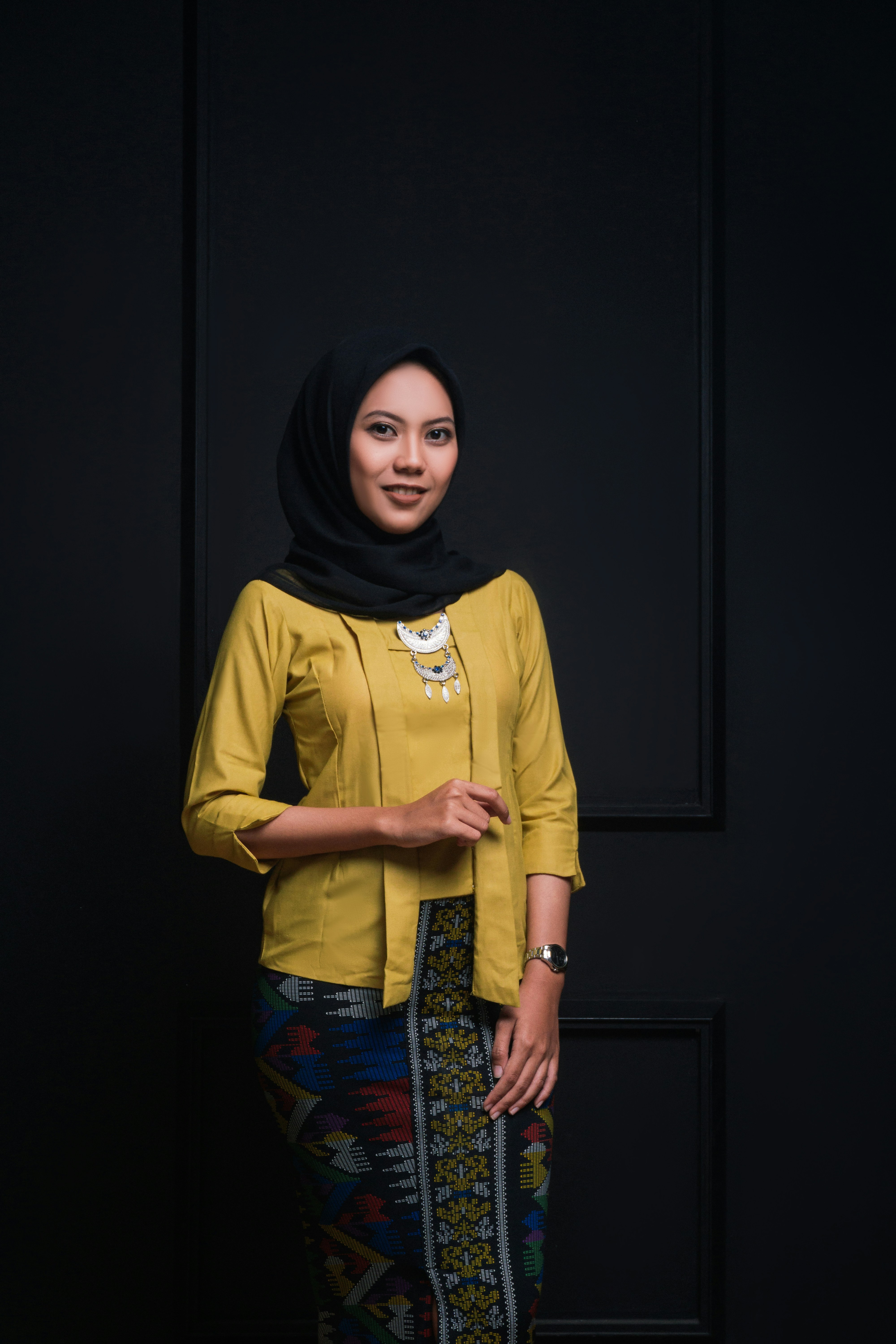 wanita dengan kemeja lengan panjang kuning dan hijab hitam