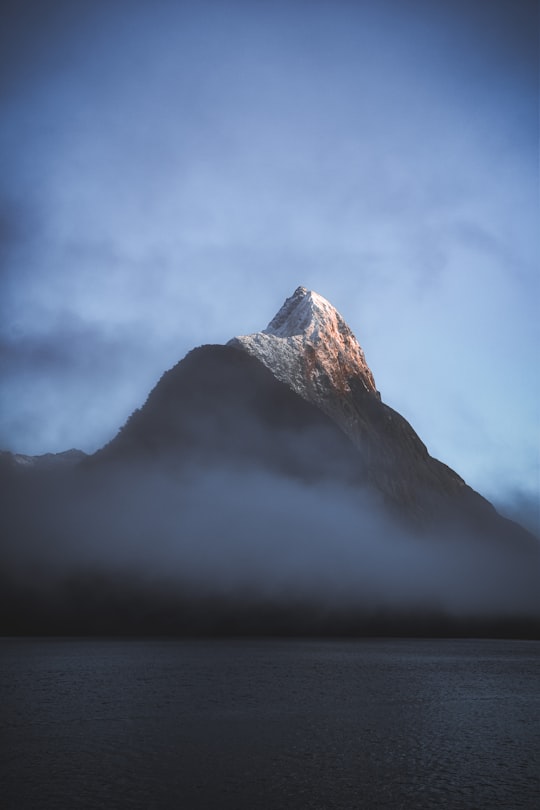 white and black mountain under white clouds in Milford Sound New Zealand