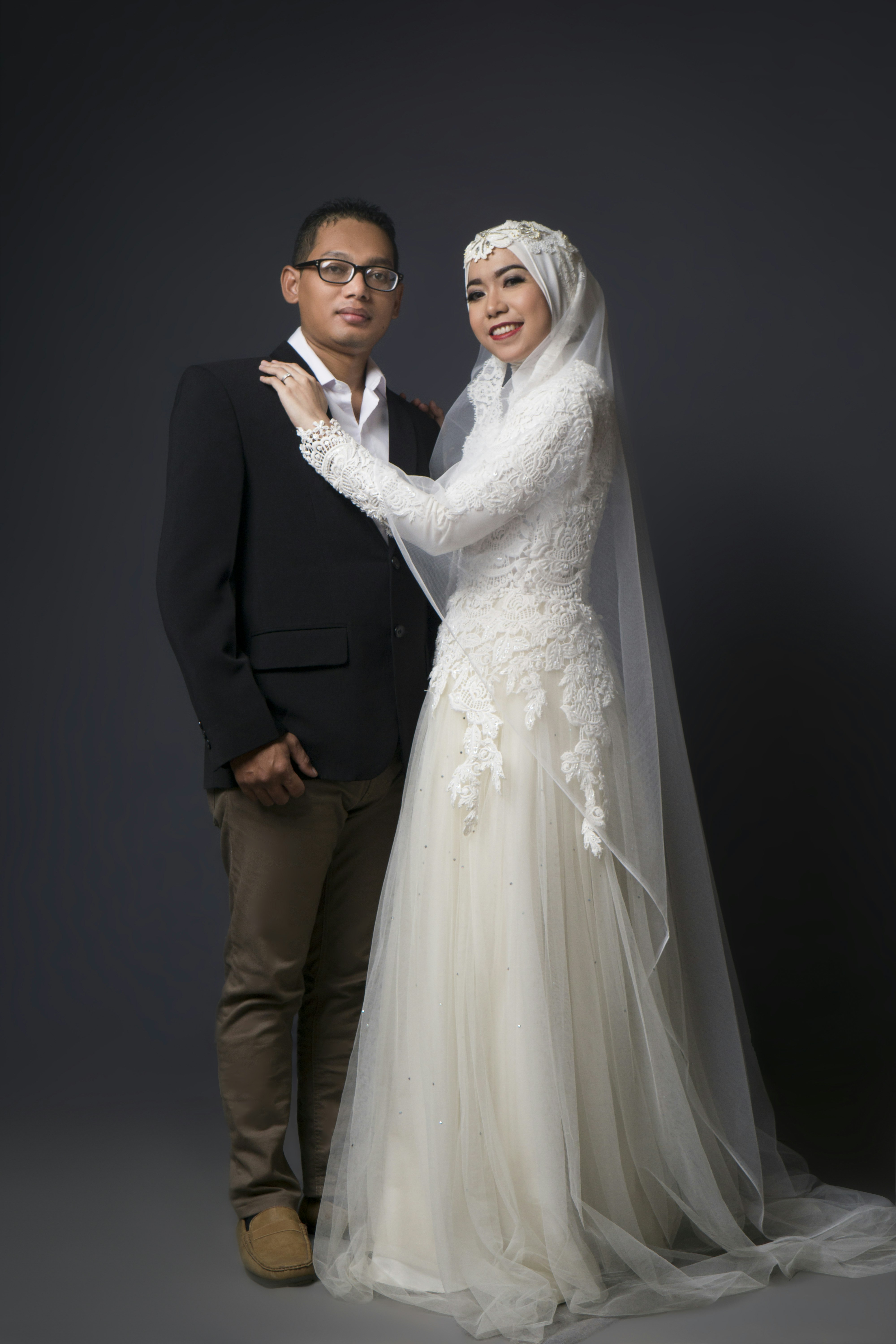 wanita dengan gaun pengantin putih dan pria berjas hitam