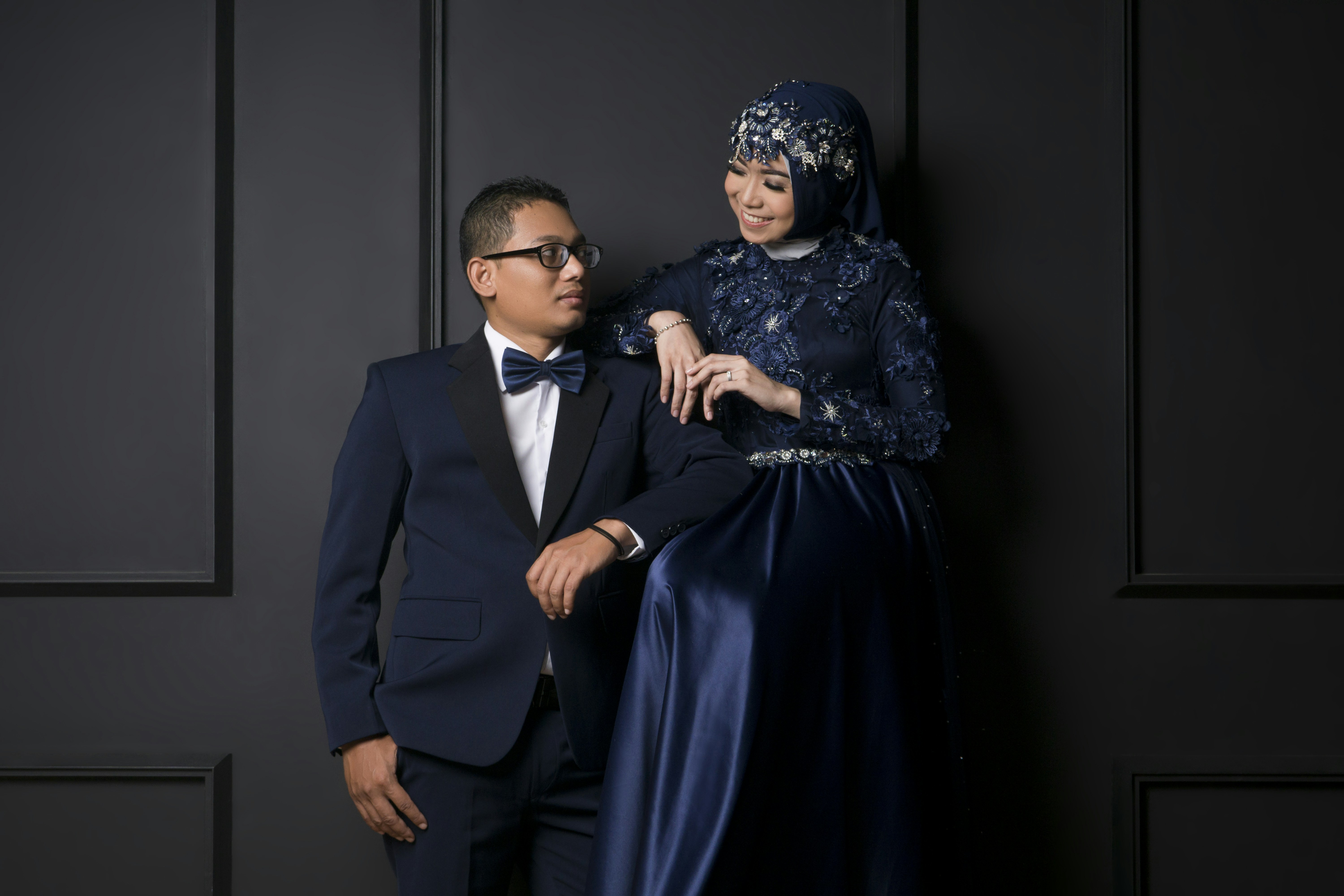 Man in black suit jacket and woman in blue dress