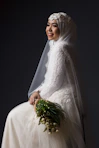 woman in white wedding dress holding bouquet of flowers