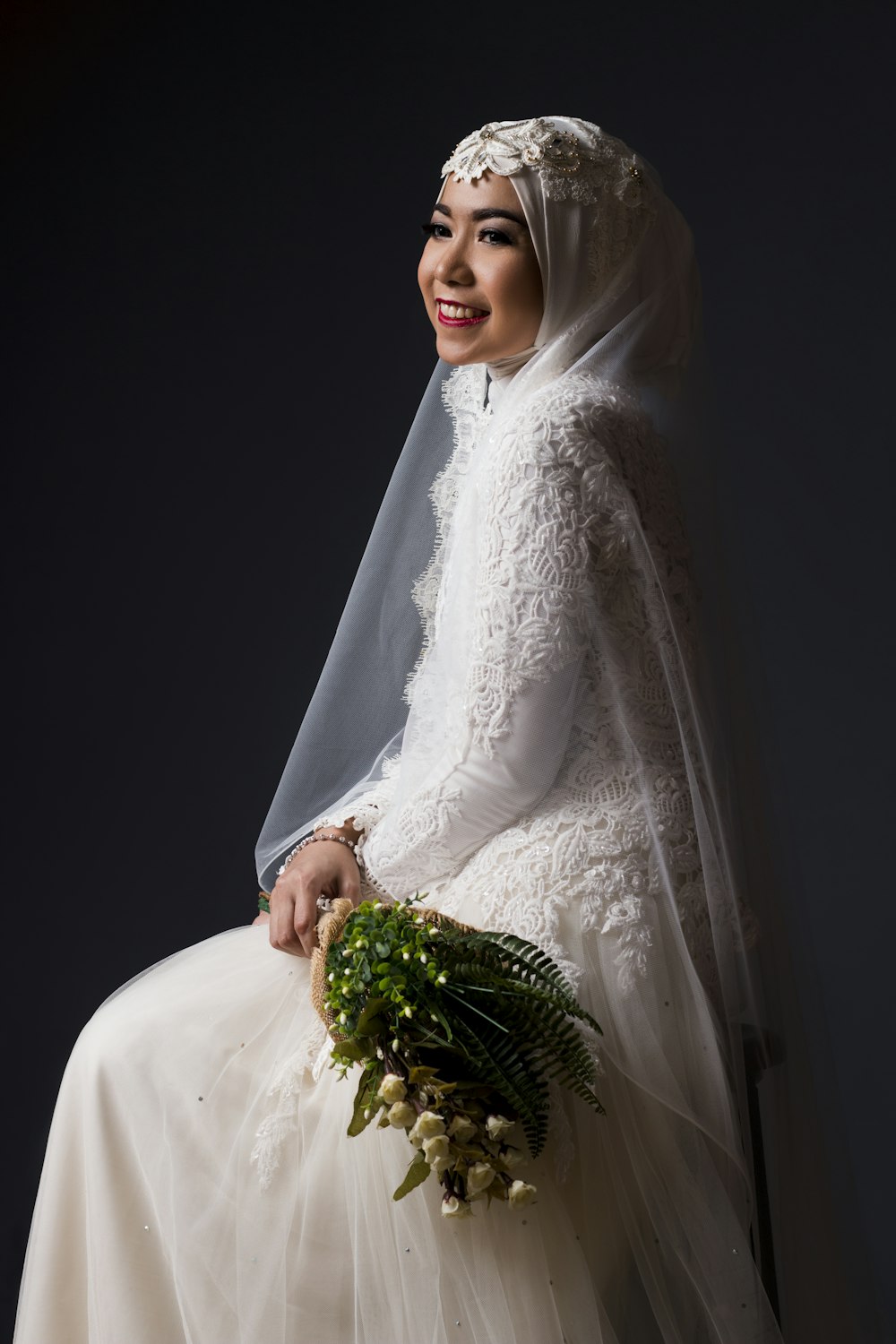 woman in white wedding dress holding bouquet of flowers