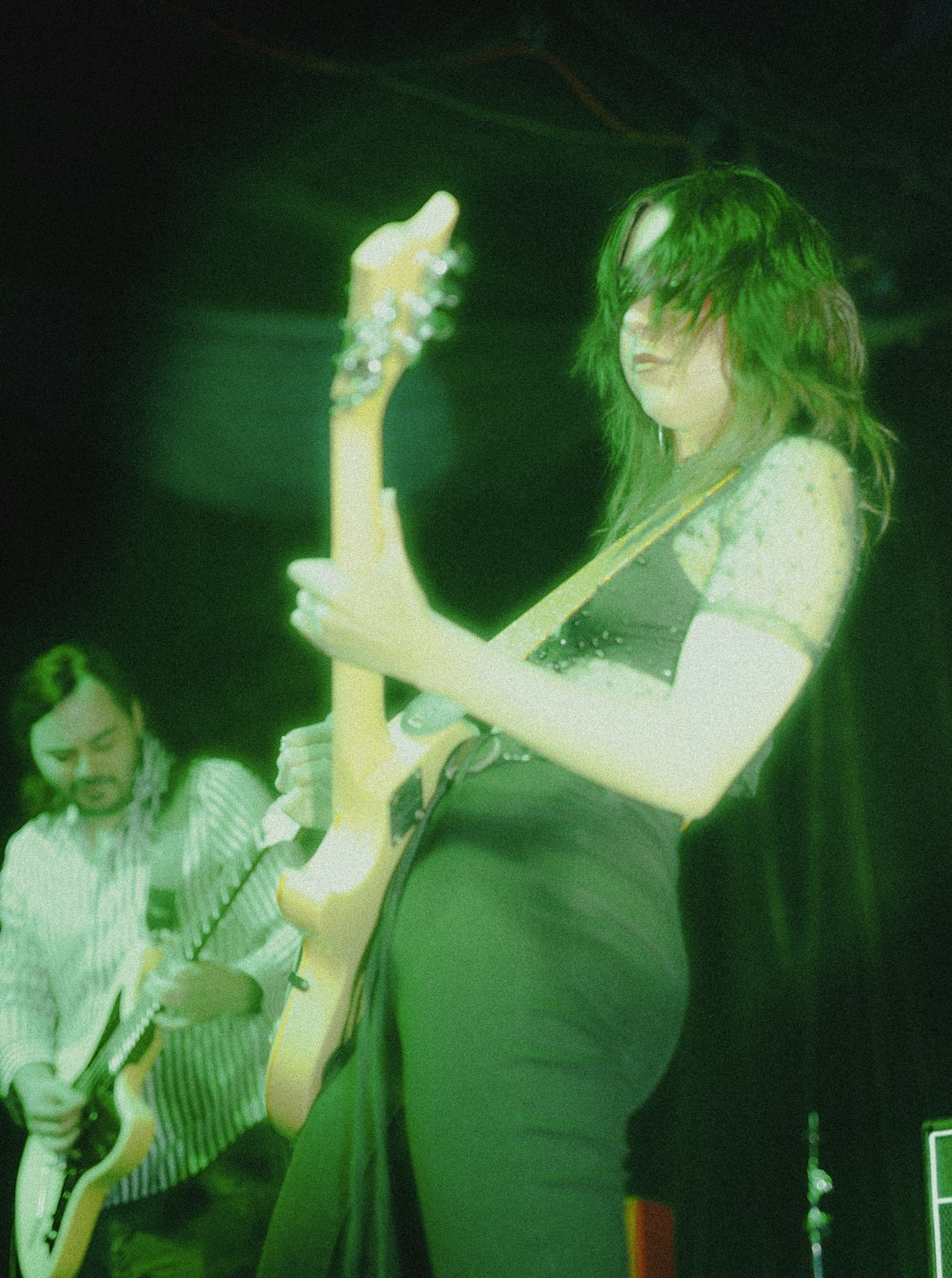 woman in green dress holding electric guitar