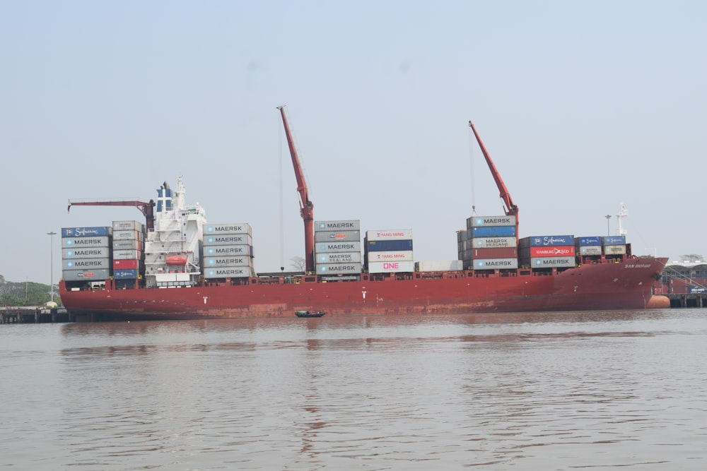red cargo ship on sea during daytime