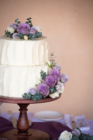 white cake with pink flower on top