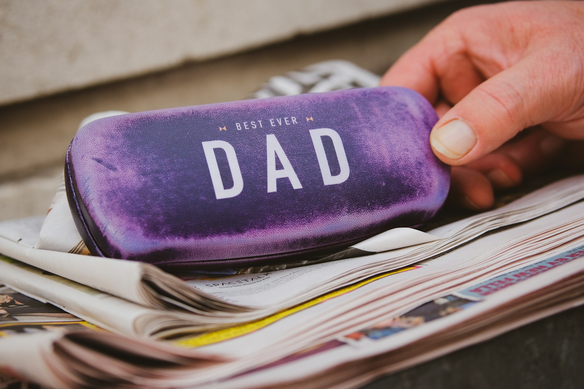 person holding purple and white UNK case