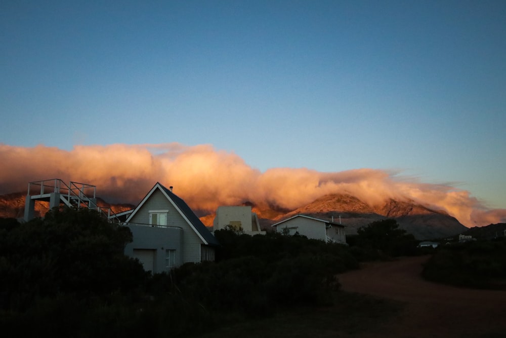 Casa blanca y negra cerca de árboles verdes bajo el cielo azul durante el día