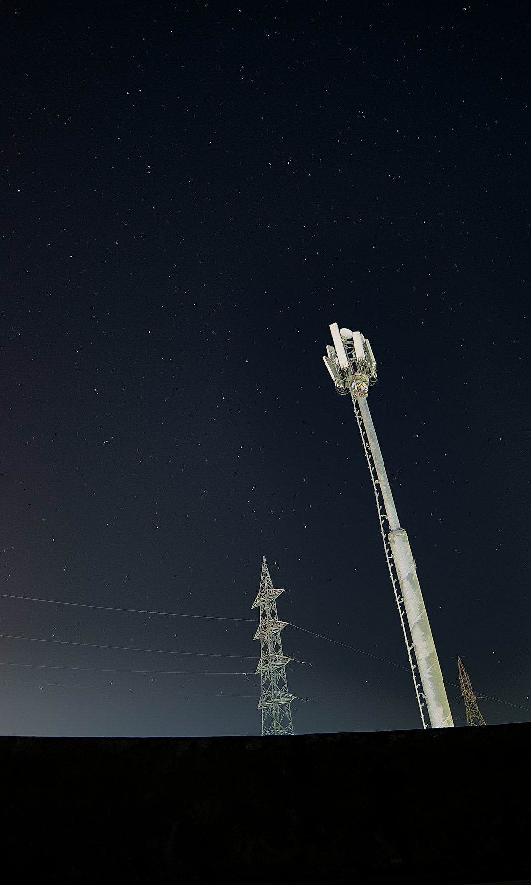 white and black satellite tower under black sky