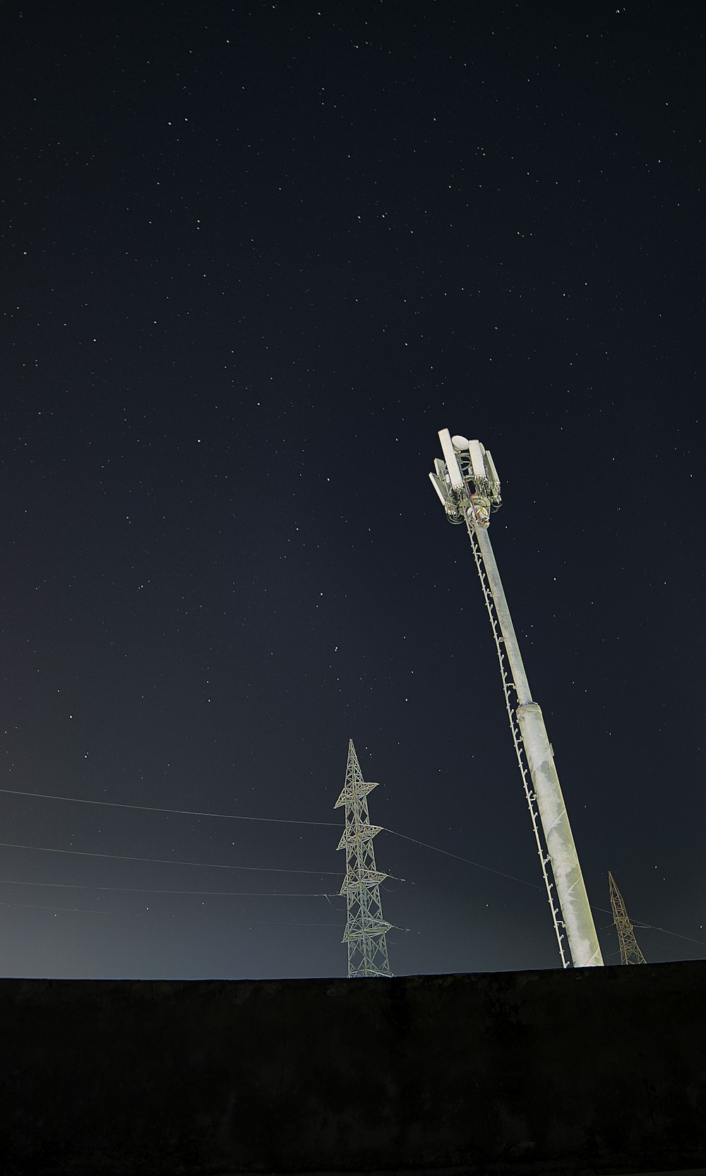 Torre satellitare bianca e nera sotto il cielo nero