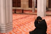 man in black robe sitting on red floor