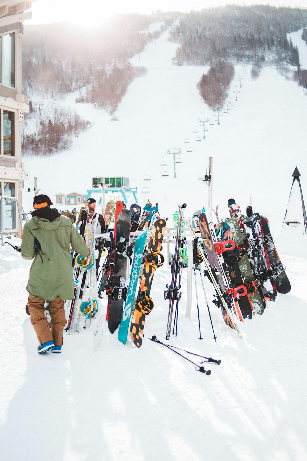 people in green jacket and pants with ski blades on snow covered ground during daytime