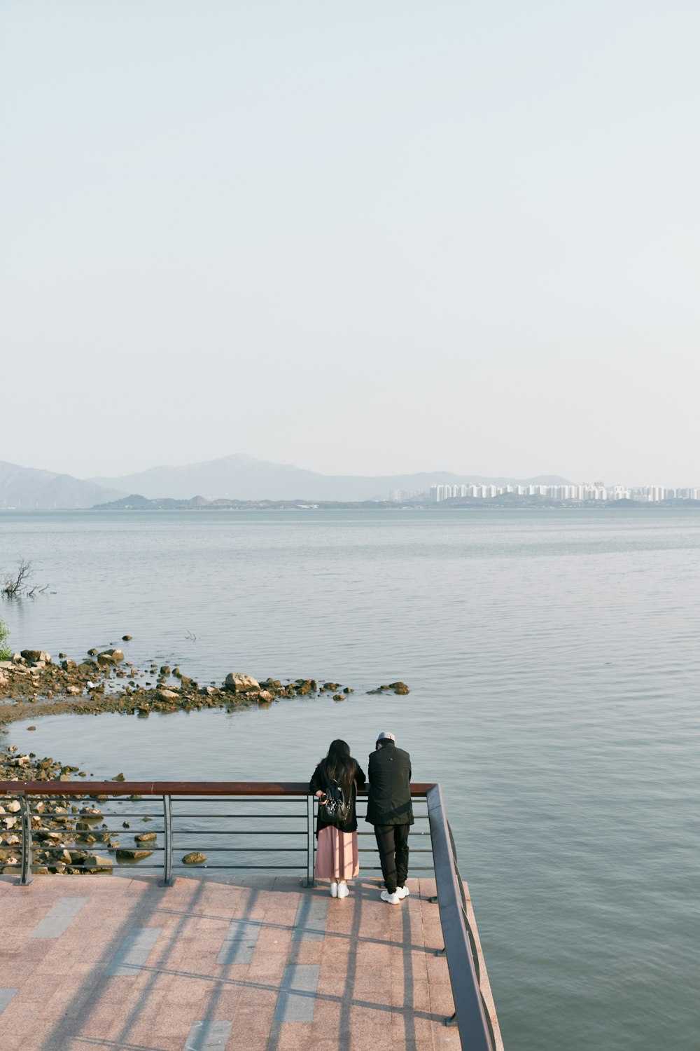 people standing on dock near body of water during daytime