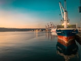 Evening view of a cargo vessel moored at a quiet riverside port.