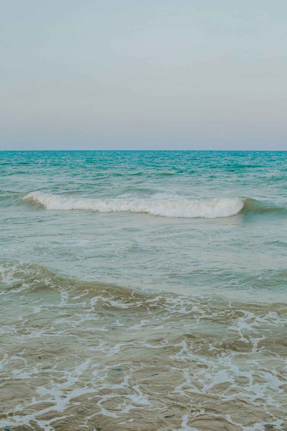 ocean waves crashing on shore during daytime