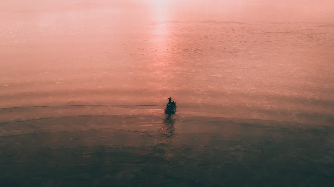 person in black wet suit on body of water during daytime