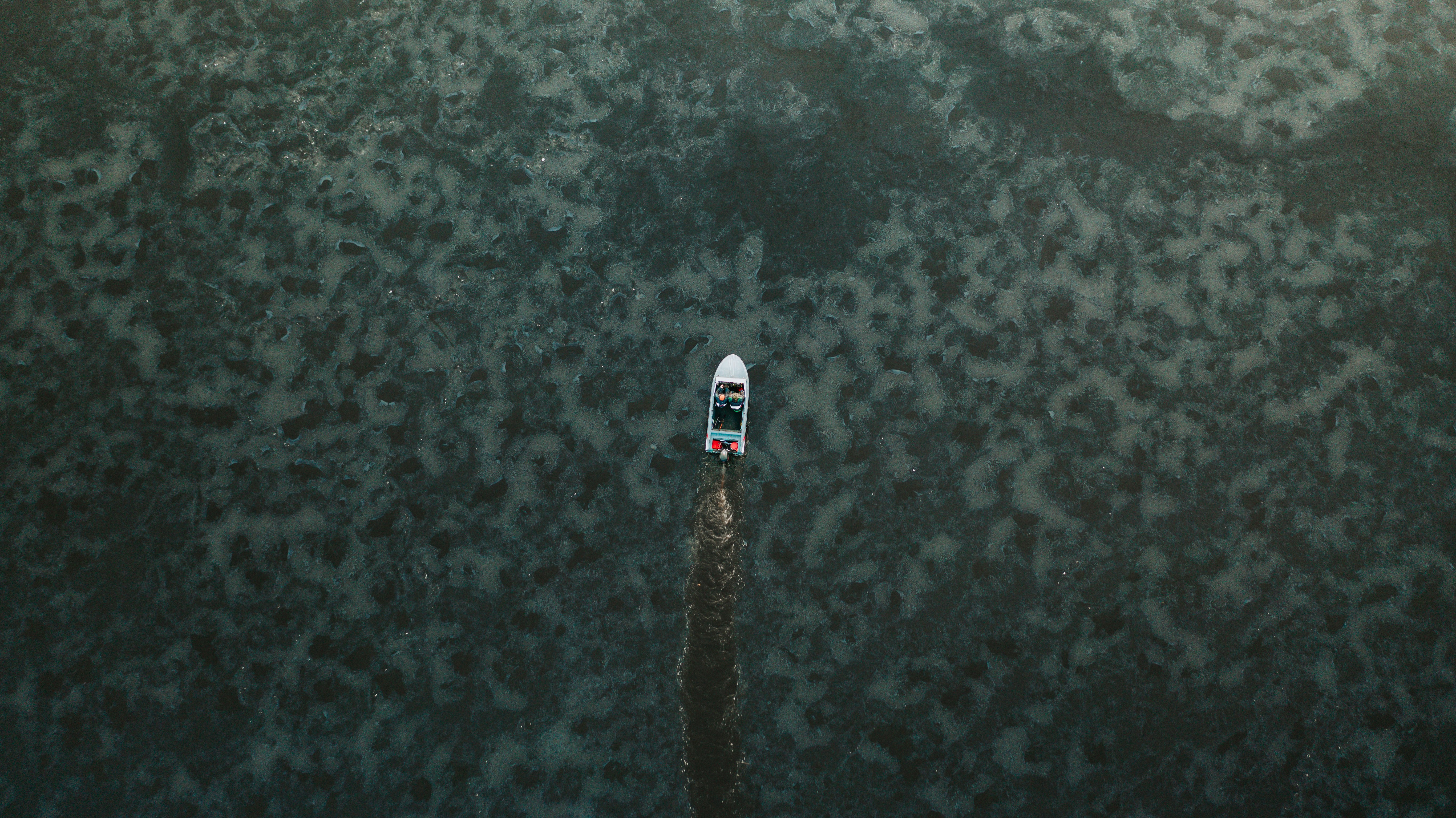 white and blue boat on body of water during daytime space shuttle teams background