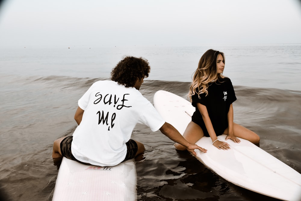 2 women sitting on beach shore during daytime