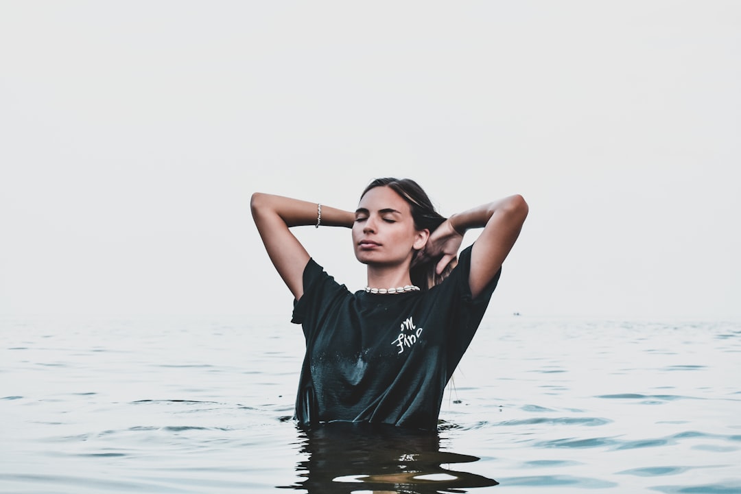 woman in black crew neck t-shirt standing on water during daytime