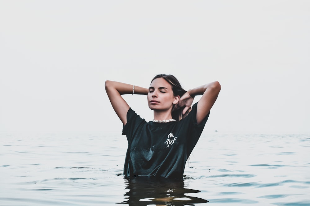 woman in black crew neck t-shirt standing on water during daytime