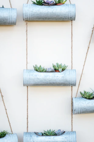 A collection of stainless steel planter boxes arranged neatly in an office lobby.