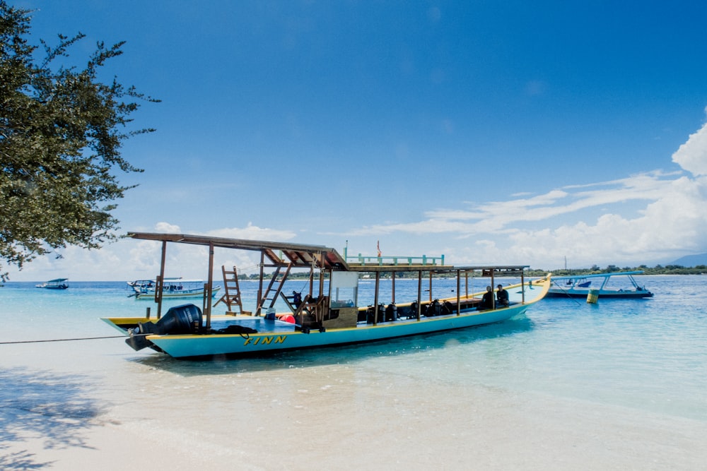 blue and white boat on white sand during daytime