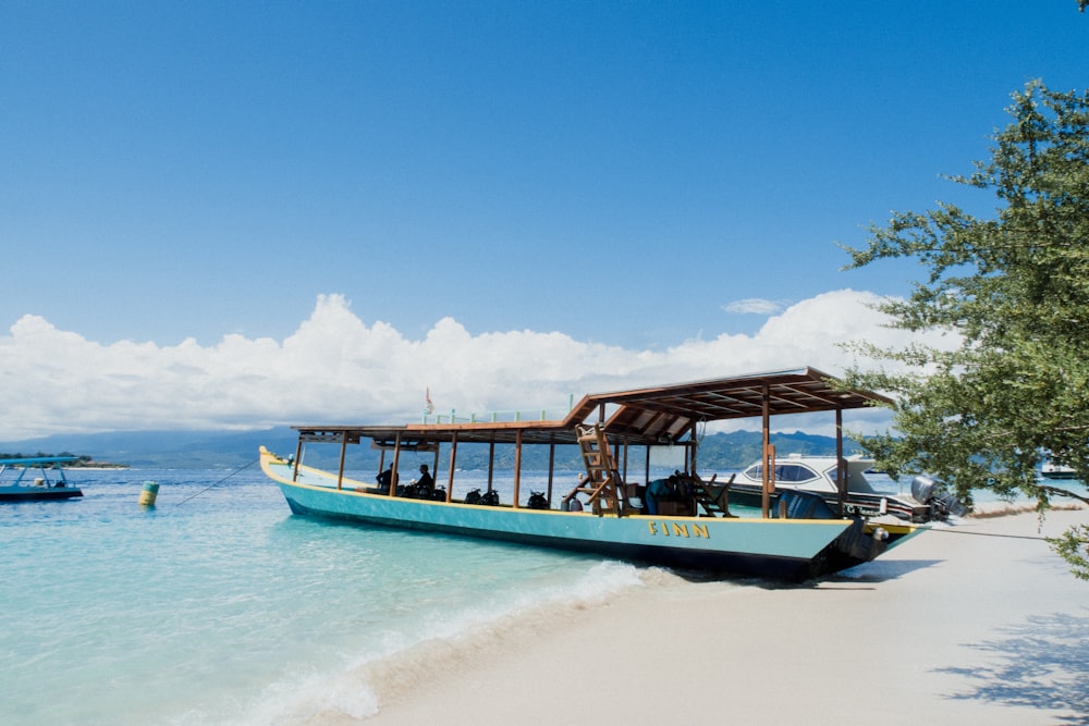 blue and white boat on beach during daytime