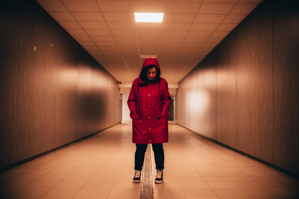 mulher no casaco vermelho de pé no corredor