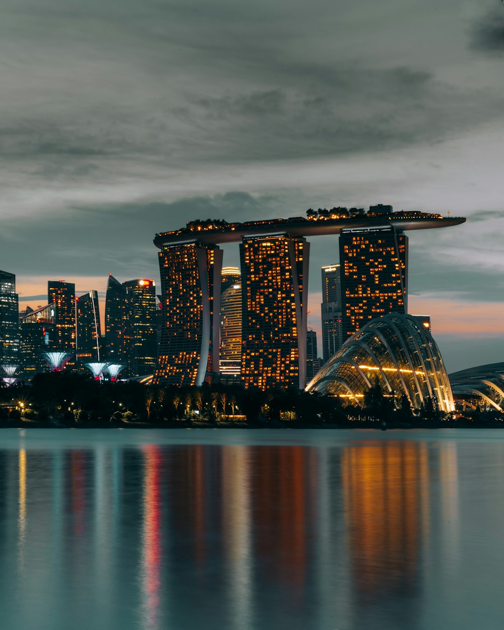 city skyline across body of water during night time