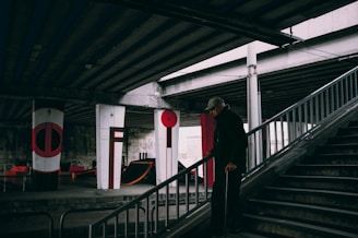 A volunteer helping an elderly person safely navigate their home with handrails.