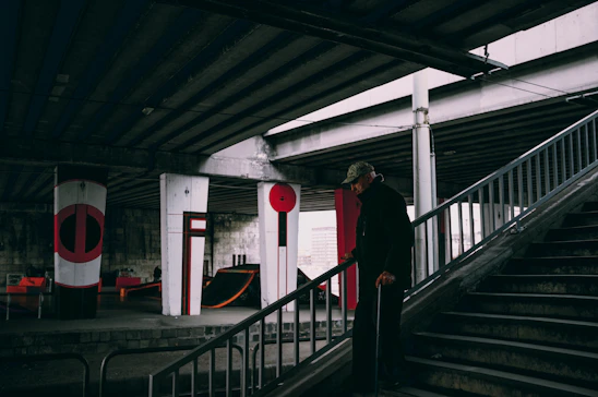 An elderly person smiling confidently while using an easystep assisted device to climb stairs at home.