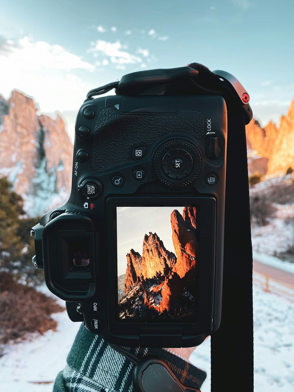 black dslr camera taking photo of brown rock formation during daytime