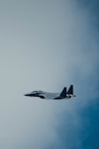 Close-up of a sleek modern fighter jet soaring through a clear blue sky.